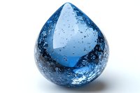 Luminous blue glass water drop with air bubbles captured inside against white background, macro photography showing liquid-like texture and transparency.