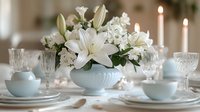 Elegant table setting with white lily floral centerpiece in porcelain bowl, crystal glasses and lit candles. Romantic wedding reception or fine dining atmosphere.
