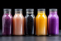 Colorful assortment of fresh smoothies in glass bottles with metal lids on dark background, featuring purple, orange, black, yellow and pink beverages.