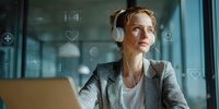 Young businesswoman in gray blazer with headphones gazing thoughtfully out office window while working on laptop, surrounded by digital interface elements.