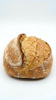 Artisan sourdough bread loaf with golden crust isolated on white background for bakery and food design projects.
