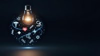 Glowing light bulb surrounded by floating medical icons and symbols on dark background representing healthcare innovation and technology solutions.