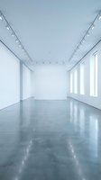 Empty white gallery room with polished concrete floor and track lighting system for art exhibitions and contemporary displays.