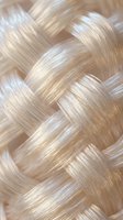 Luxurious blonde hair braid close-up showing silky smooth texture and golden highlights for beauty and haircare concepts.