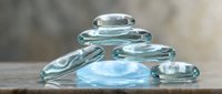 Clear water droplets and puddles on wooden surface, showcasing liquid transparency and reflection effects for design and advertising projects.