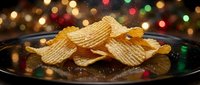 Golden crispy potato chips on dark plate with festive colorful bokeh lights background for holiday party snacks and celebration food concepts.