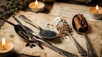 Ancient herbal medicine tools with seeds, spoons and candles on aged parchment creating mystical apothecary atmosphere for natural healing concepts.