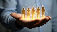 Business professional holding glowing human figures in palm representing team management, leadership development, and human resources strategy.