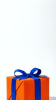 Bright orange gift box with blue ribbon bow isolated on white background, ready for holiday, birthday, and celebration design projects.