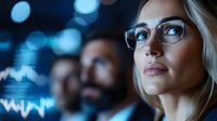 Young blonde Caucasian businesswoman in glasses analyzing digital data visualization with blue bokeh lights in modern office environment.