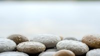 Smooth river stones arranged in zen meditation setting with soft natural lighting and peaceful minimalist composition for wellness and relaxation concepts.