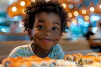 Young African American child with natural curly hair smiling joyfully at sushi rolls on table, warm bokeh lights creating magical restaurant atmosphere.