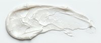 White cosmetic cream or moisturizer smear isolated on light background, suitable for skincare product packaging, beauty advertising, and cosmetic design projects.