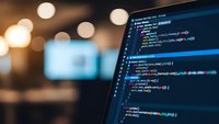 Close-up of computer screen displaying colorful programming code in modern office environment with warm bokeh lights in background for web development projects.