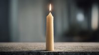 Single burning candle with warm flame on textured surface creating peaceful ambiance for meditation, relaxation, and spiritual moments in soft lighting.
