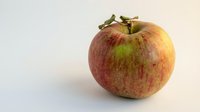 Fresh red and yellow apple with green stem isolated on white background, suitable for food packaging, recipe blogs, and healthy eating designs.