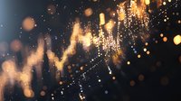 Glowing golden bokeh lights and sparkles create magical atmosphere with blurred light trails against dark background, abstract festive holiday backdrop.