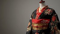 Traditional black and red floral kimono with ornate obi belt displayed on mannequin against neutral background, showcasing intricate Japanese textile craftsmanship.