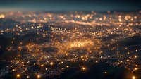 Aerial view of glowing city lights at night creating magical bokeh effect with warm orange tones and blurred depth of field. Urban landscape from above.