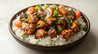 Spiced meatballs with fresh herbs and vegetables served over fluffy white rice in rustic ceramic bowl for food blogs, restaurant menus and cooking content.