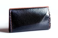 Black leather wallet with red stitching details on white background, showing texture and craftsmanship of handmade accessory. Isolated product photography.