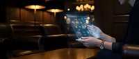 Professional businesswoman using digital tablet with glowing interface in modern restaurant setting. Technology meets hospitality industry concept.