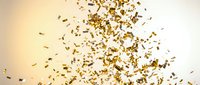 Golden confetti pieces floating and falling through air against warm gradient background for celebration and party designs.