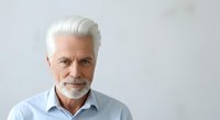 Senior man with white hair and beard wearing light blue shirt, isolated on white background for portrait and professional use.