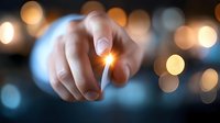 Finger pointing at glowing light effect against blurred bokeh background creates magical atmosphere for business vision and innovation concepts.