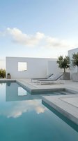 Modern minimalist white villa with infinity swimming pool reflecting blue sky and clouds on luxury terrace for vacation rental marketing.