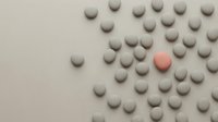 Minimalist composition with gray spheres and one standout coral sphere on neutral background for modern design concepts and uniqueness themes.