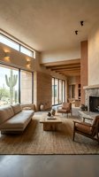Modern desert home living room with exposed wooden beams, large windows, neutral tones, contemporary furniture and southwestern architectural design elements.