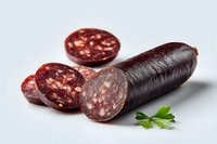 Traditional blood sausage with slices showing texture and fat inclusions, garnished with fresh parsley on white background.