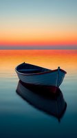 Wooden boat floating on calm water during dramatic sunset with orange sky reflection. Peaceful seascape with single empty rowing vessel at dusk.