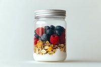Healthy breakfast parfait with fresh berries, granola and yogurt in mason jar on white background for meal prep and nutrition concepts.