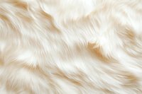 Luxurious cream white faux fur texture with soft wavy pattern creates elegant background for fashion, textile and interior design projects.