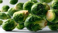 Fresh Brussels sprouts with water droplets on white background, showcasing vibrant green color and texture for healthy cooking and food photography.
