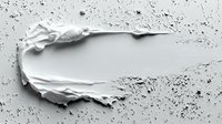 White cosmetic cream smear with scattered powder particles on light background for skincare and beauty product advertising campaigns.