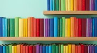 Colorful rainbow books arranged on wooden shelves creating vibrant library display for education, reading and learning concepts in organized bookcase.