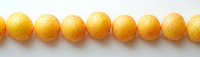 Row of bright yellow round beads arranged in straight line on white background, showing jewelry making supplies and craft elements for design projects.