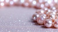 Delicate pink pearls scattered on glittery surface creating romantic composition with soft bokeh effect and shallow depth of field for wedding and luxury designs.