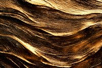 Luxurious wavy brown and gold hair texture closeup with highlights and natural shine, creating abstract pattern of flowing curves and lines for beauty and fashion designs.