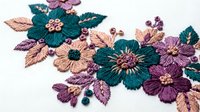 Colorful embroidered flowers with teal, purple and pink blooms on white fabric. Decorative floral needlework for fashion, crafts and textile design projects.
