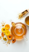 Herbal tea with dried calendula and ginkgo biloba flowers arranged on white background, overhead view for wellness and natural remedy design projects.