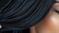 Close-up of woman with sleek black hair covering part of face showing smooth healthy strands and natural skin texture for beauty and haircare concepts.