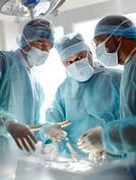 Surgical team in protective gear collaborating during operation, focused on patient under bright operating room lights.