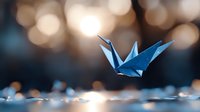 Blue origami crane flying over reflective surface with soft bokeh lights creating magical atmosphere. Artistic paper craft photography.