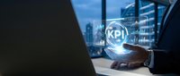 KPI key performance indicator metrics displayed on digital sphere in businessman's hand with city skyline and data analytics charts in background for business performance measurement.