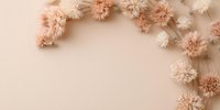 Delicate dried flowers creating elegant border frame on soft beige background. Natural floral composition in pastel pink and cream tones for wedding design.