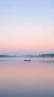 Solitary wooden boat floating on calm misty river at dawn, surrounded by forested shoreline under soft pink and blue sky. Serene landscape for travel and nature projects.